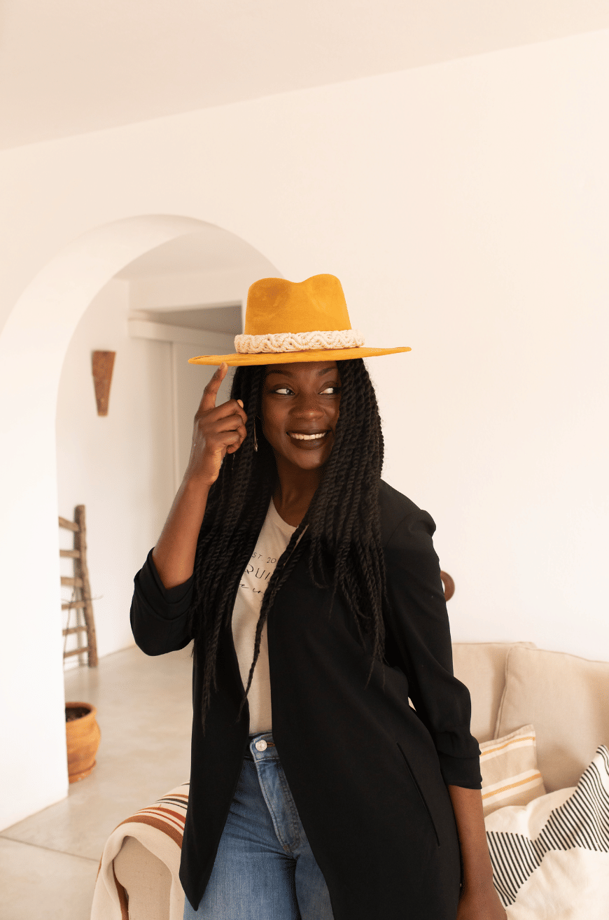 A yellow colored hat made in Mexico made from synthetic suede back with an ivory colored macrame hat accessory